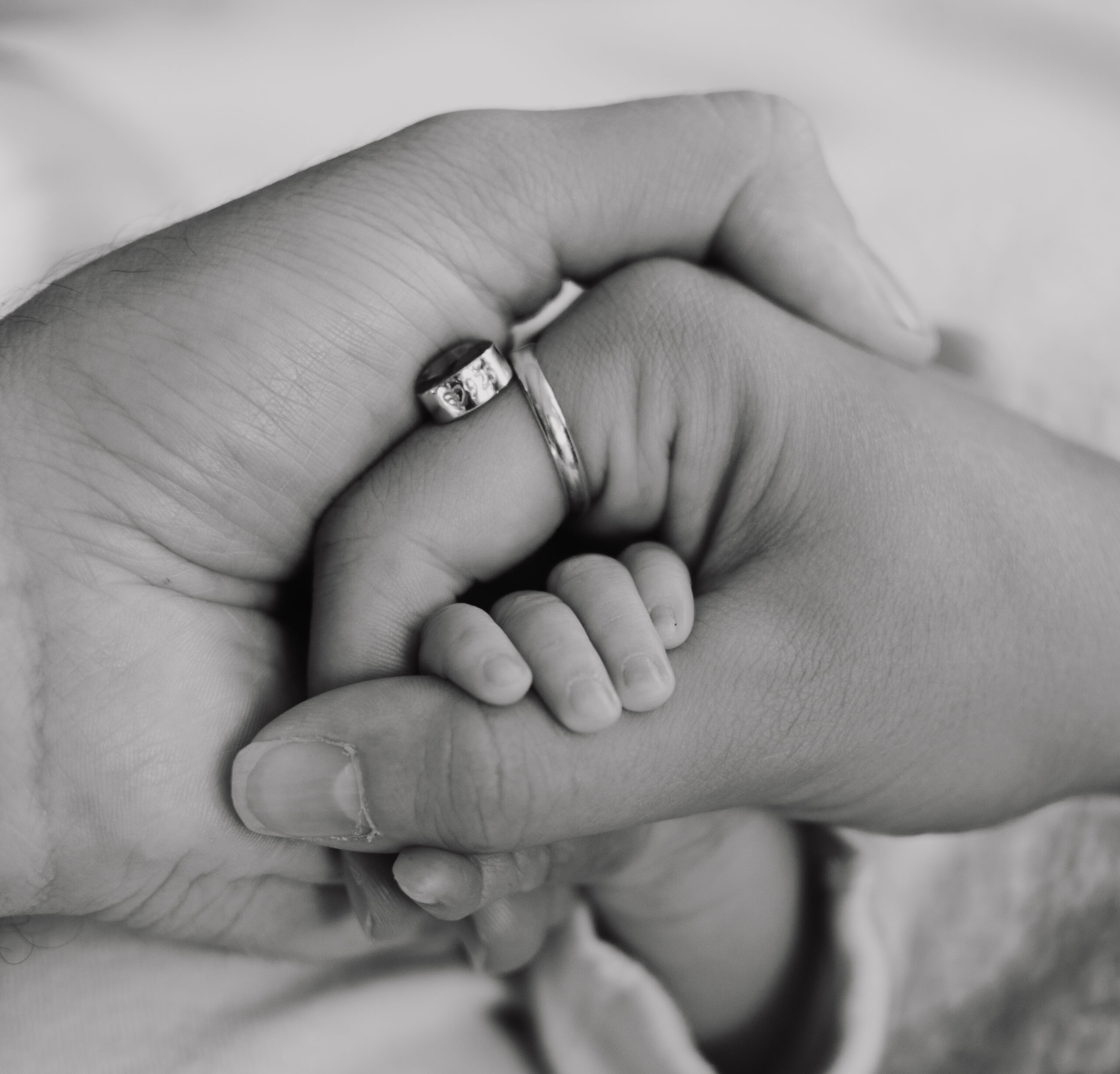parents holding hands newborn baby photoshoot